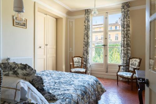 une chambre avec un lit, des chaises et une fenêtre dans l'établissement Cardinale 4 rooms, à Aix-en-Provence
