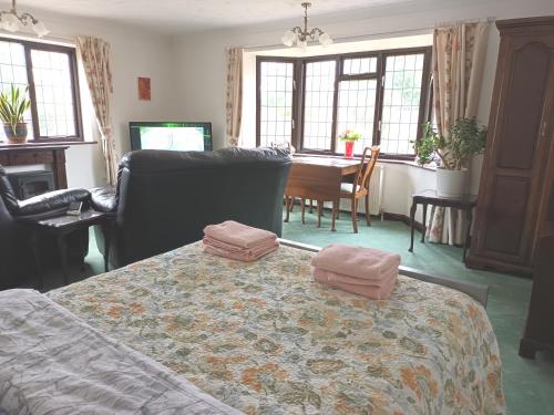 a bedroom with a bed with two towels on it at The Chantry, North Wing, Cottage in Hemsby
