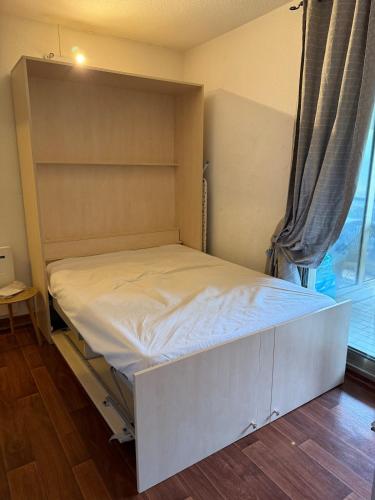 un lit dans une chambre avec une grande fenêtre dans l'établissement Studio cosy Cannes centre, à Cannes