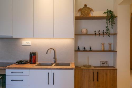 eine Küche mit weißen Schränken und einer Spüle in der Unterkunft Aluna Boutique Suites in Vasilikos