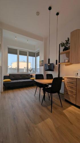 Una sala de estar con una mesa y sillas y un sofá. en Kaunas City Centre Apartment Self Check-In & AC, en Kaunas