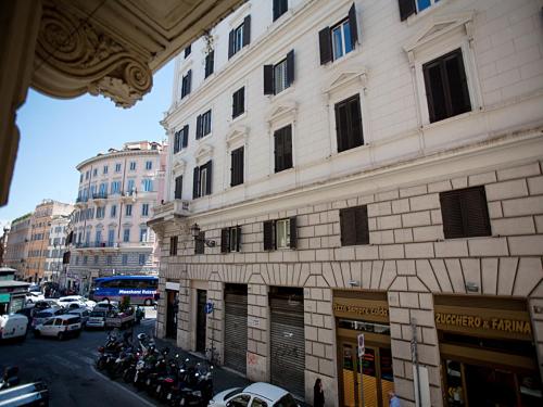 wysoki budynek z samochodami zaparkowanymi na ulicy miejskiej w obiekcie Rome Holiday Home w Rzymie