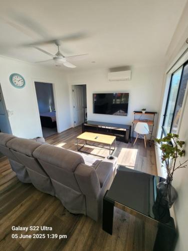a living room with a couch and a table at Suburban Paradise With a Pool in Petrie