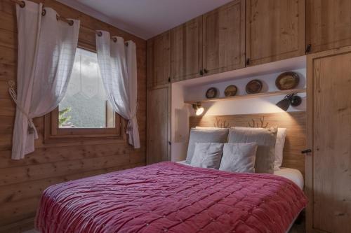 une chambre avec un lit avec une couverture rouge et une fenêtre dans l'établissement Grande Jorasses 2 - Ski - Terrasse - Vue Montagne, aux Houches