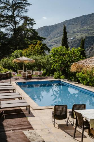 a swimming pool with chairs and a table at Quinta de S. Jose - Turismo Rural in Ervedosa do Douro