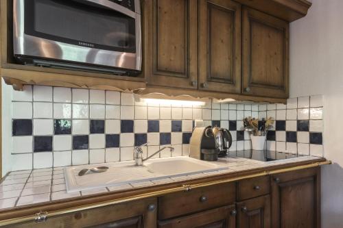 une cuisine avec un évier et un micro-ondes dans l'établissement Grande Jorasses 2 - Ski - Terrasse - Vue Montagne, aux Houches