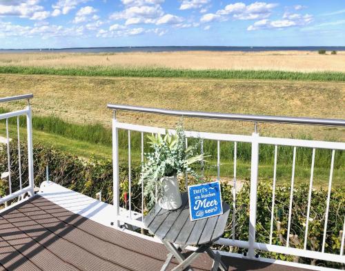 a sign sitting on a chair on a porch at Sonniges Strandhaus mit Wasserblick am Haff mit 2 Schlafzimmern für 4 Pers in Mönkebude