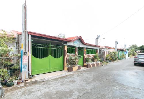 a green building with plants on the side of a street at Jb's Transient House in General Trias