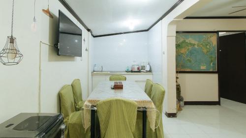 a room with a table and chairs and a kitchen at Jb's Transient House in General Trias