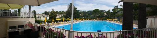 une grande piscine avec chaises et parasols dans l'établissement Apartment Loubet- 2 Bedroom flat with views, à Villeneuve-Loubet