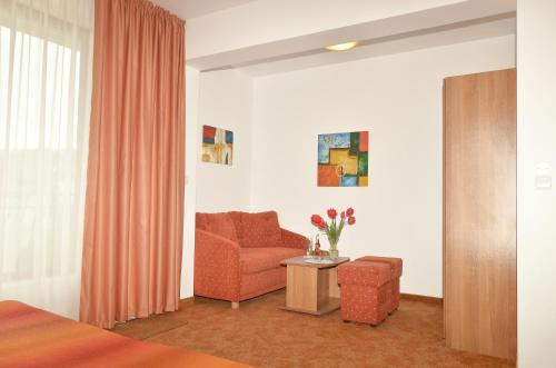 a living room with a couch and a chair at Family Hotel Vega in Saints Constantine and Helena