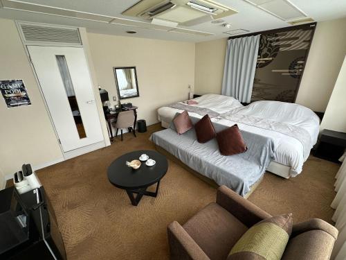 a hotel room with two beds and a couch at 9STAY Fukui Station in Fukui
