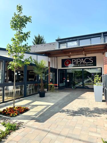 a building with a pspas sign in front of it at Pipacs Panír & Grill Garden Vendégház in Győrújbarát
