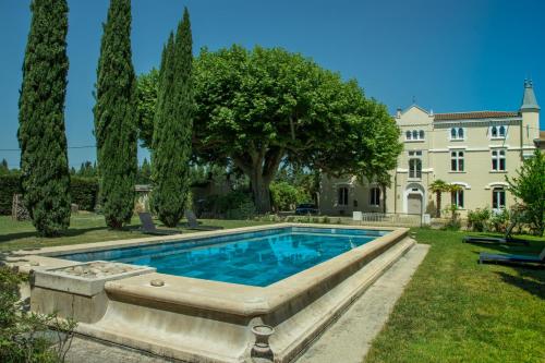 une piscine devant une maison avec des arbres dans l'établissement Château vert, à Cavaillon