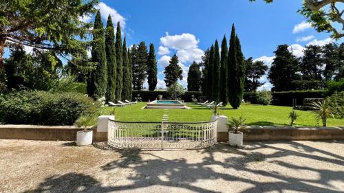 une porte dans un parc avec des arbres et une fontaine dans l'établissement Château vert, à Cavaillon