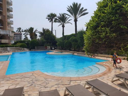 une personne debout en face d'une piscine dans l'établissement L'Estérel, à Cannes