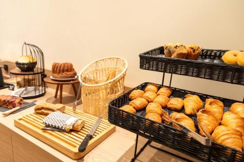 a bunch of breads and pastries in baskets on a table at Hôtel Terra Vinum in Gueberschwihr