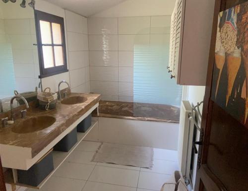 une salle de bain avec deux lavabos et une baignoire dans l'établissement Le hameau des pins, à Boulouris-sur-Mer