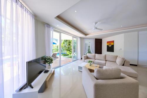 a living room with a couch and a tv at Baan Rim Talay in Nathon