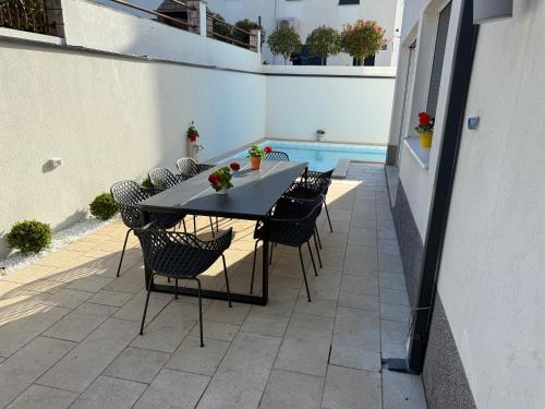 a patio with a table and chairs and a pool at Rooftop Spa in Trogir