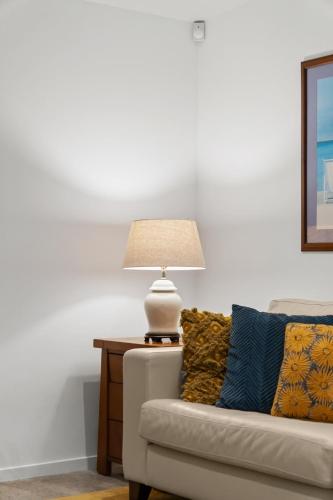 a lamp sitting on a table next to a couch at 120m to Wainui Beach - Modern Coastal Unit in Gisborne