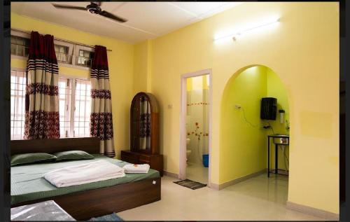 a bedroom with a bed with a green wall at Baruahs Inn 4 in Guwahati