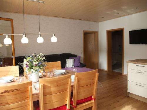 a living room with a dining room table with flowers on it at Geigerbauernhof in Mühlenbach