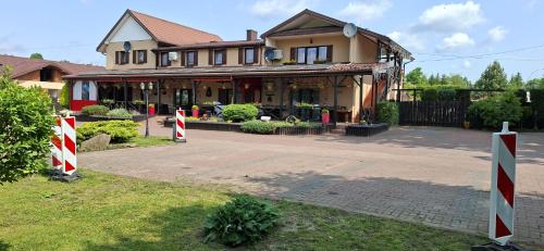 una casa con cartelli rossi e bianchi davanti di Stajnia pod Dębem a Starachowice