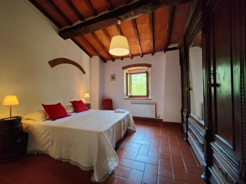 a bedroom with a bed with red pillows on it at I Giardini di Marcello in Dicomano