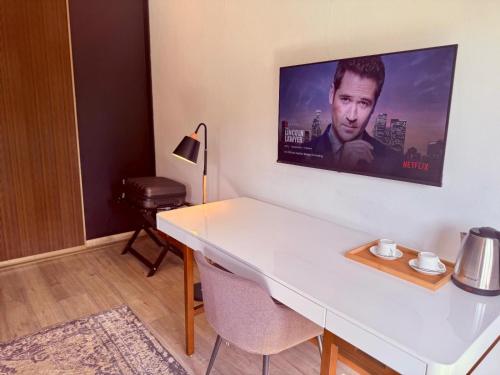 a room with a white desk with a tv on the wall at NO4 Lilliput - Sandton Executive Guest House - OPENING SPECIAL in Sandton