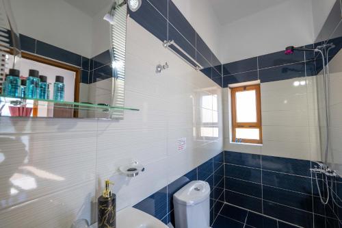 a bathroom with a toilet and a glass shower at Vila Eden in Ksamil