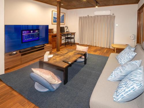 a living room with a couch and a tv at Guest House -海- in Takamatsu