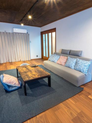 a living room with a couch and a coffee table at Guest House -海- in Takamatsu