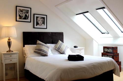 a bedroom with a large white bed with a black headboard at Bego's Apartment in Aberdeen