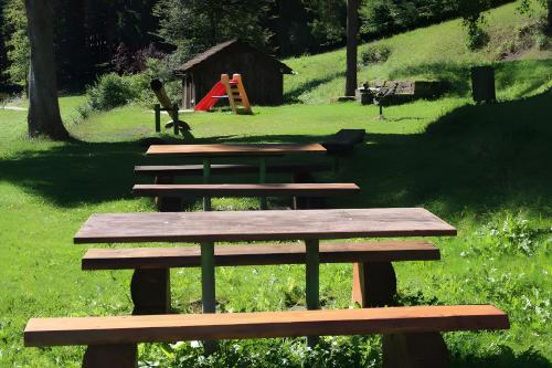 a group of wooden picnic tables in a park at Enri Theater und Pension Bruderhaus in Altensteig
