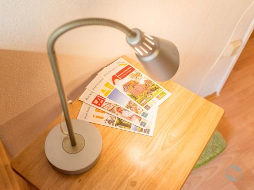 a table with a lamp and a magazine on it at Enri Theater und Pension Bruderhaus in Altensteig