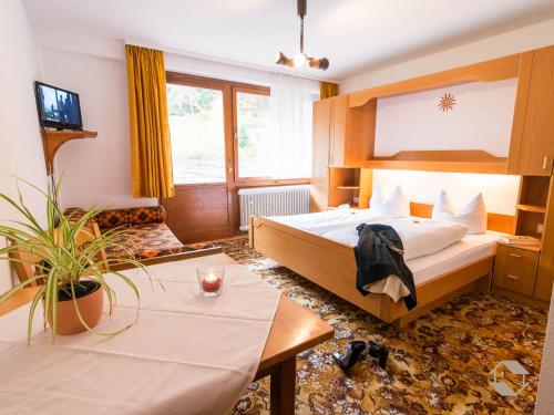 a hotel room with a bed and a table at Enri Theater und Pension Bruderhaus in Altensteig