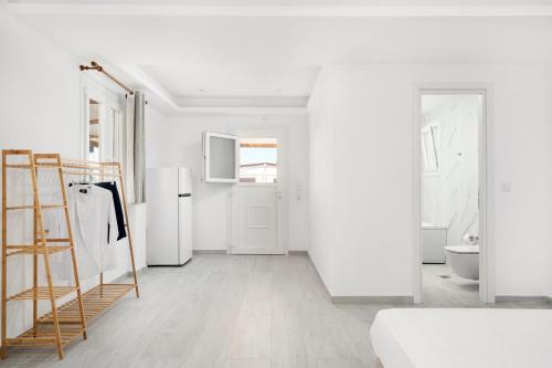 a white room with a refrigerator and a kitchen at Grozos Rooms in Parikia