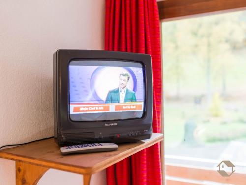 a television sitting on a table with a remote control at Enri Theater und Pension Bruderhaus in Altensteig