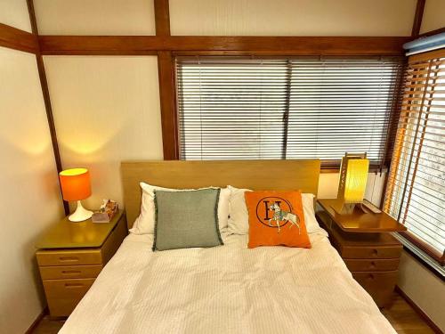 a bedroom with a bed with an orange pillow on it at TOKYO HOSHI VILLIA-Private Villa in Tokyo ideal for groups and families in Tokyo