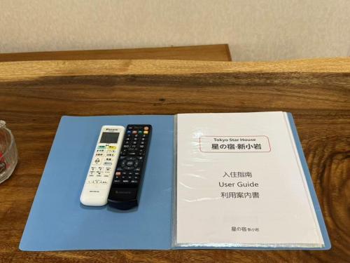 a book with two remote controls sitting on a table at TOKYO HOSHI VILLIA-Private Villa in Tokyo ideal for groups and families in Tokyo