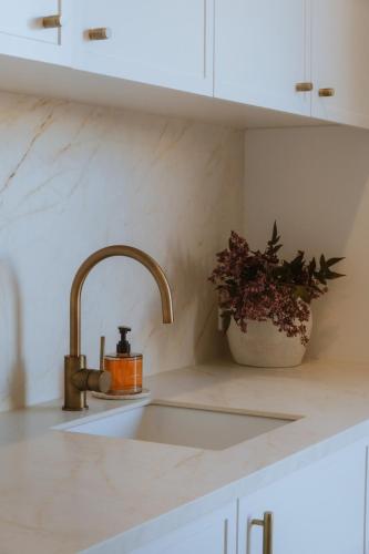 a kitchen sink with a candle and a potted plant at Villa Alora in Exmouth