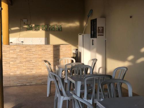 een groep tafels en stoelen met een koelkast bij Chácara GLclube 