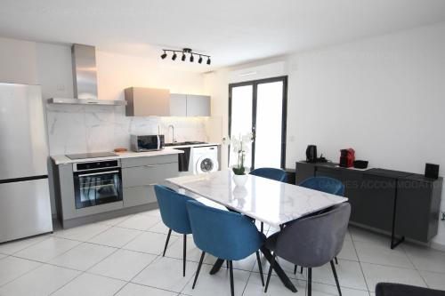 - une cuisine avec une table et des chaises bleues dans l'établissement Paradisio, à Cannes