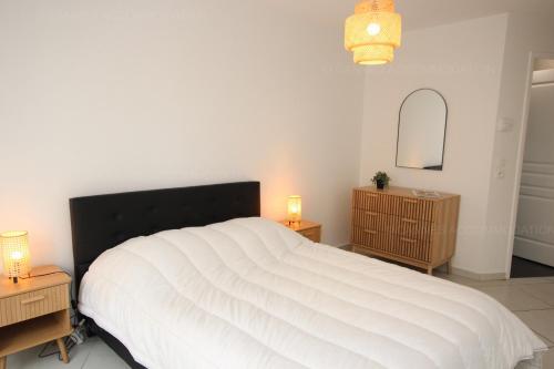 une chambre avec un grand lit blanc avec deux tables de nuit dans l'établissement Paradisio, à Cannes