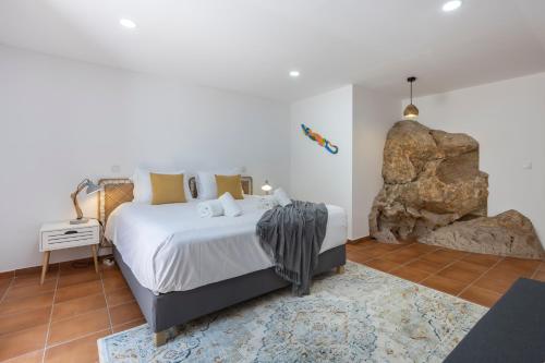 a bedroom with a large bed and a large rock at Salema Family Home in Salema