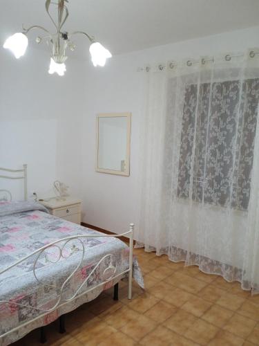 a bedroom with a bed and a window with curtains at Casetta Capanne in Capanne