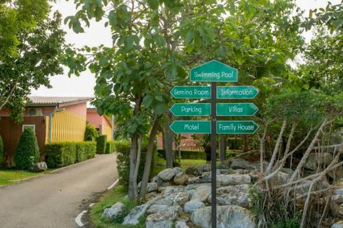 a street sign in front of a house at Baan Phing Phu Praew Cha-Am Resort บ้านพิงภูแพรว รีสอร์ท ชะอำ in Cha Am