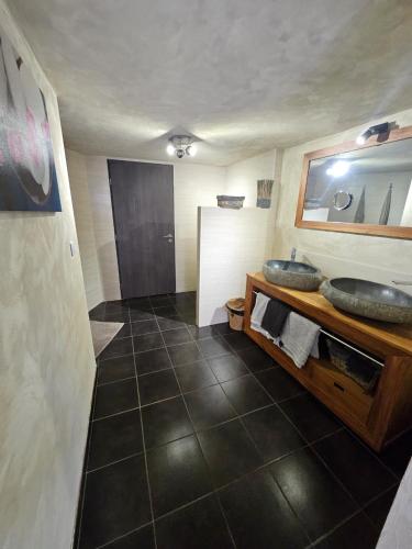 une salle de bain avec un lavabo et un miroir dans l'établissement La Pinède D'Estarac, à Bages