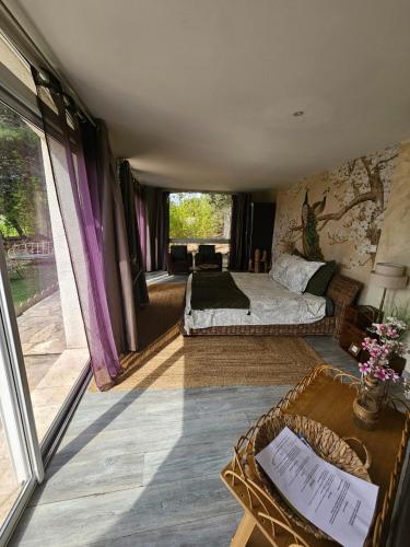 une chambre avec un lit et une grande fenêtre dans l'établissement La Pinède D'Estarac, à Bages